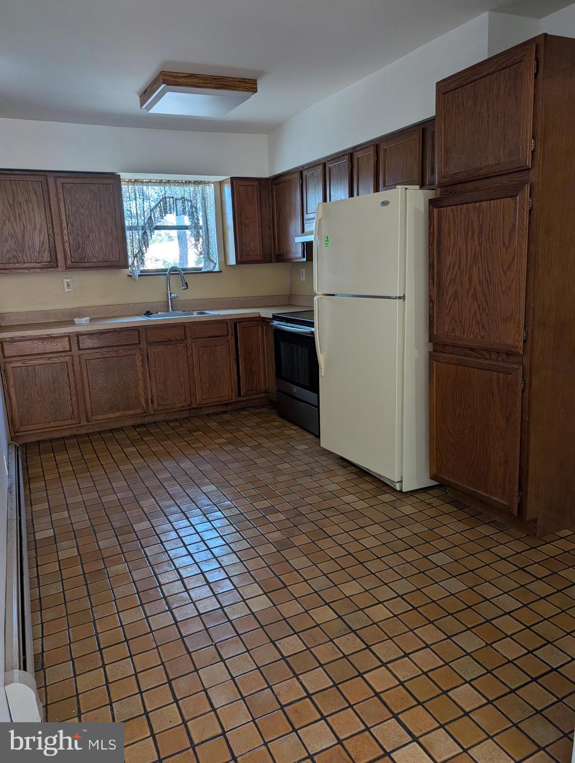 2258 State Rd. Bensalem, PA 19020 - Photo 4 of 13 a kitchen with a refrigerator a stove top oven a sink and cabinets