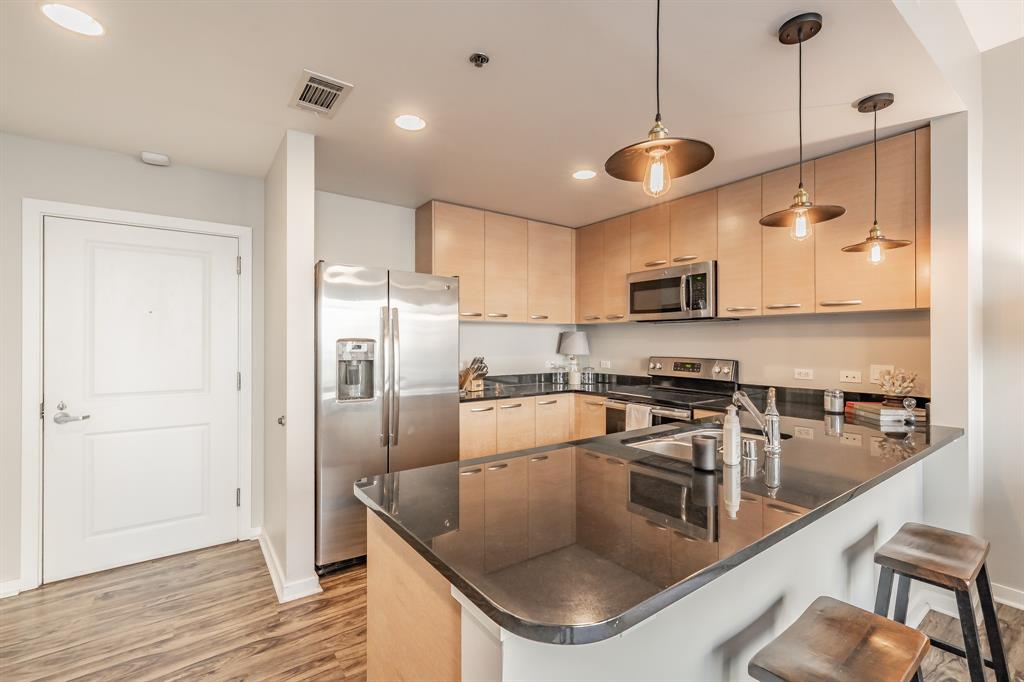 1200 Main Street, Unit 812 Dallas, TX 75202 - Photo 9 of 17 a kitchen with stainless steel appliances granite countertop a sink a stove and a refrigerator
