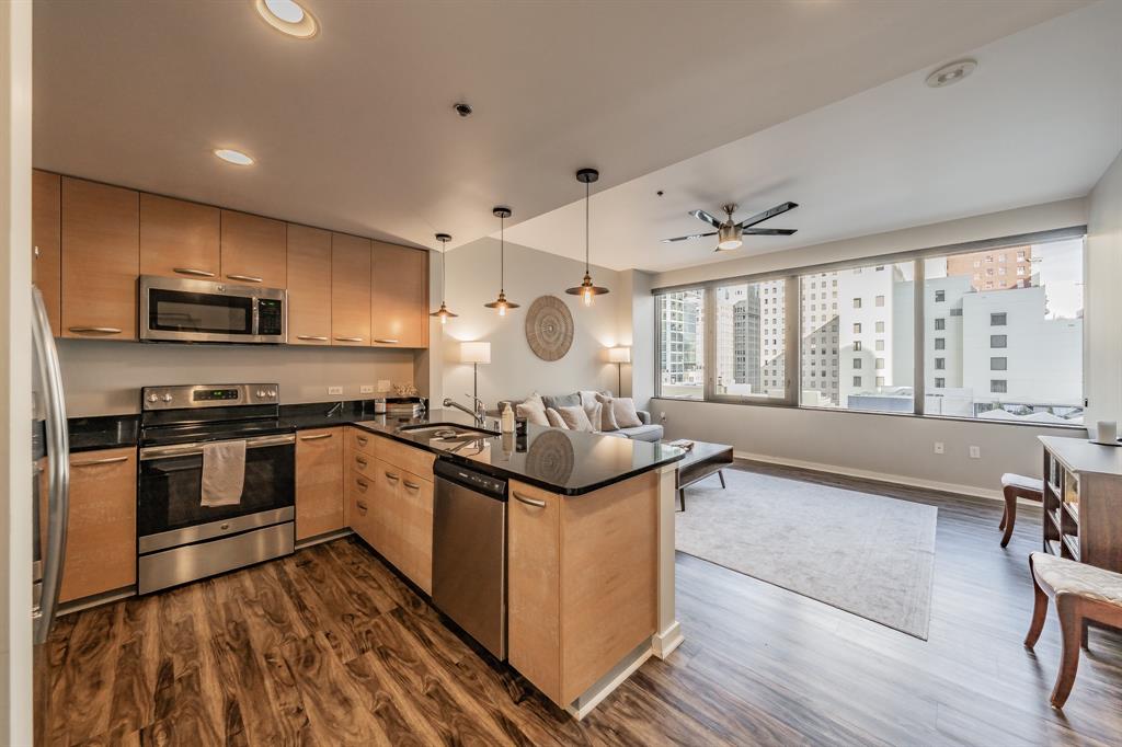 1200 Main Street, Unit 812 Dallas, TX 75202 - Photo 10 of 17 a kitchen with stainless steel appliances kitchen island granite countertop a stove and a sink