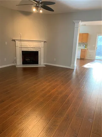 a view of empty room with wooden floor and fireplace