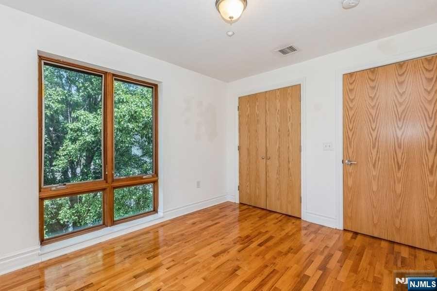 17 Meadow Road, Unit 301 Rutherford, NJ 07070 - Photo 12 of 21 a view of an empty room with wooden floor and a window