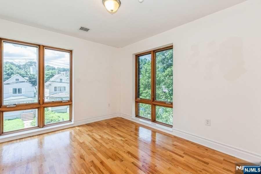 17 Meadow Road, Unit 301 Rutherford, NJ 07070 - Photo 13 of 21 an empty room with wooden floor and windows