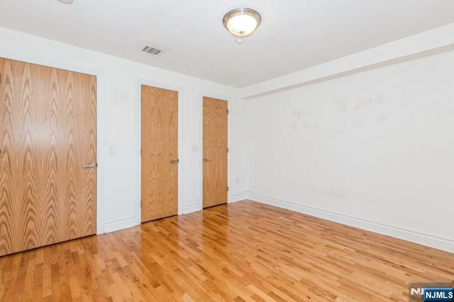 17 Meadow Road, Unit 301 Rutherford, NJ 07070 - Photo 14 of 21 an empty room with wooden floor and windows