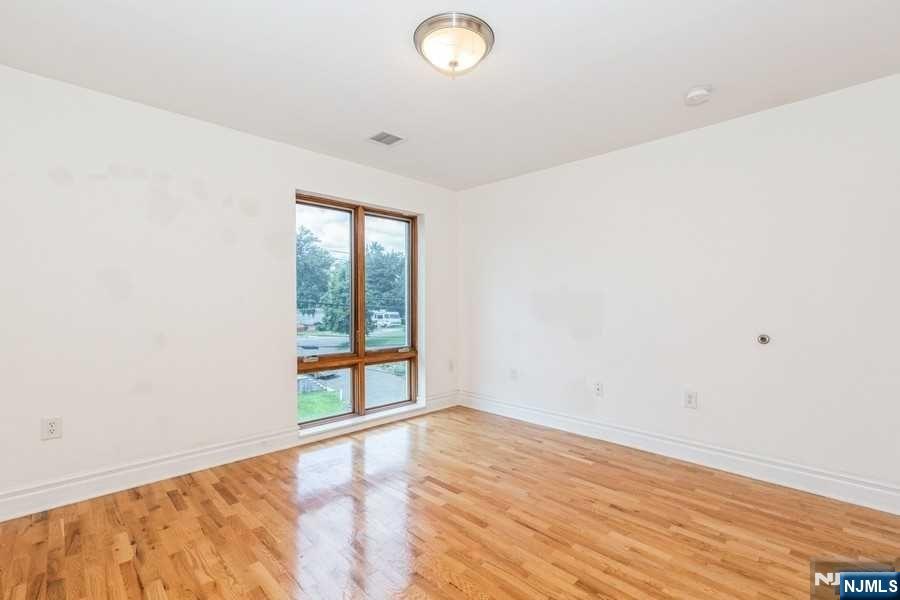 17 Meadow Road, Unit 301 Rutherford, NJ 07070 - Photo 15 of 21 an empty room with wooden floor and windows