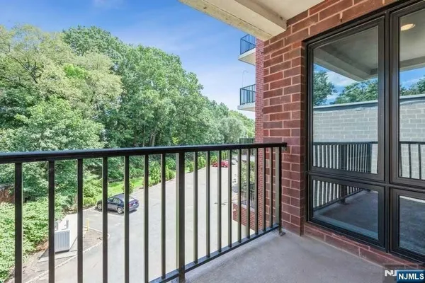 a view of a balcony with a floor to ceiling window and wooden fence