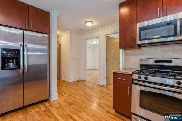 a kitchen with stainless steel appliances granite countertop a stove a refrigerator and a microwave