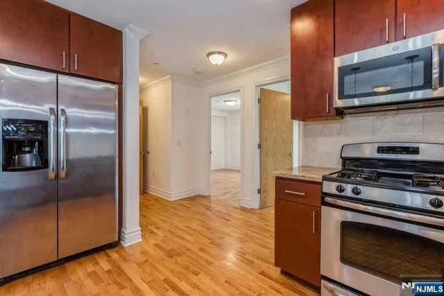 a kitchen with stainless steel appliances granite countertop a stove a refrigerator and a microwave