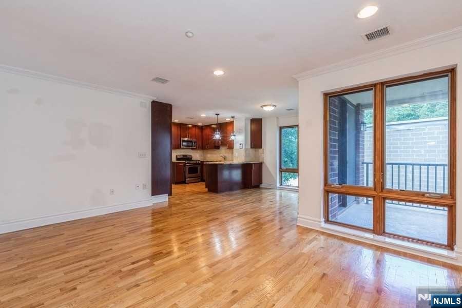 17 Meadow Road, Unit 301 Rutherford, NJ 07070 - Photo 4 of 21 an empty room with wooden floor and a large window