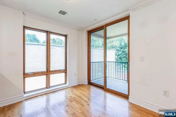 a view of a room with wooden floor and a window