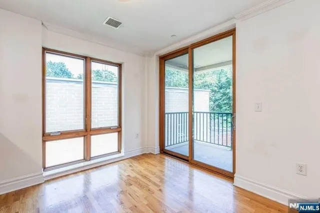 a view of a room with wooden floor and a window