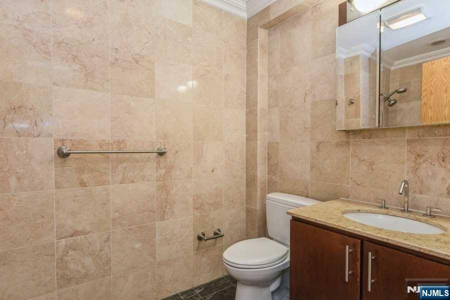 17 Meadow Road, Unit 301 Rutherford, NJ 07070 - Photo 9 of 21 a bathroom with a granite countertop sink a toilet and shower