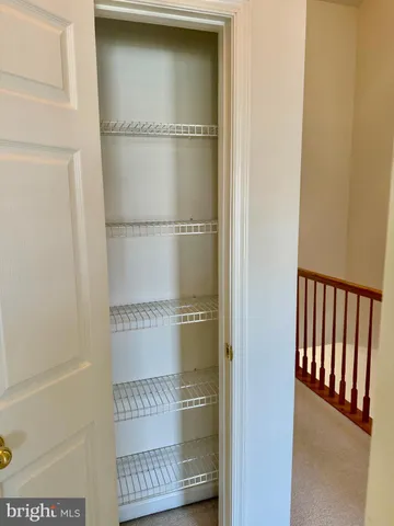 a walk in closet with wooden floor