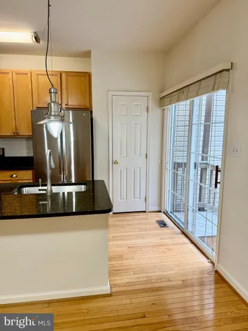 a view of a kitchen with a sink and a refrigerator