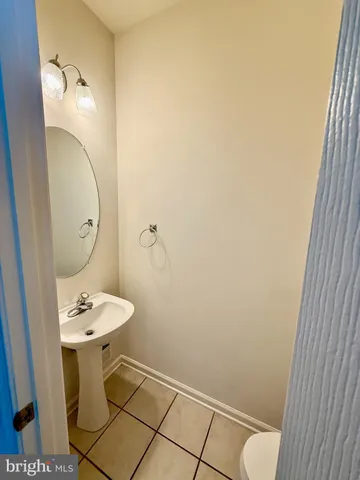 a bathroom with a sink and mirror with toilet