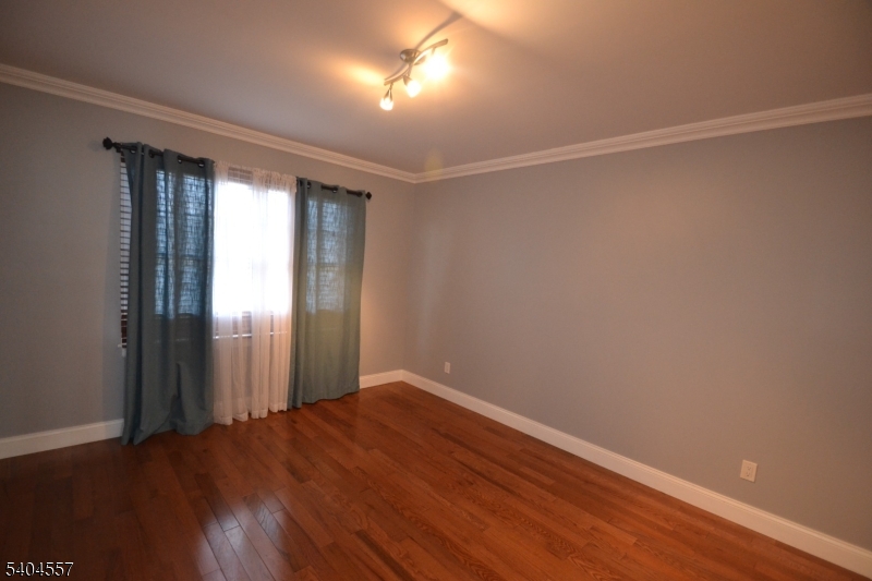 204 Market Street Garfield, NJ 07026 - Photo 27 of 36 a view of an empty room with wooden floor and a window
