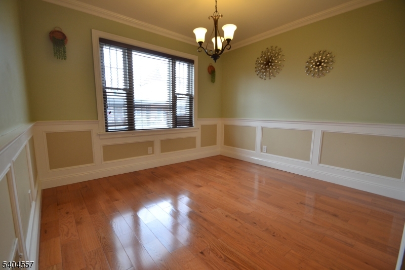 204 Market Street Garfield, NJ 07026 - Photo 8 of 36 a view of an empty room with wooden floor and a window
