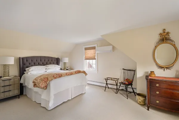 a bedroom with a bed a mirror and lamp on desk