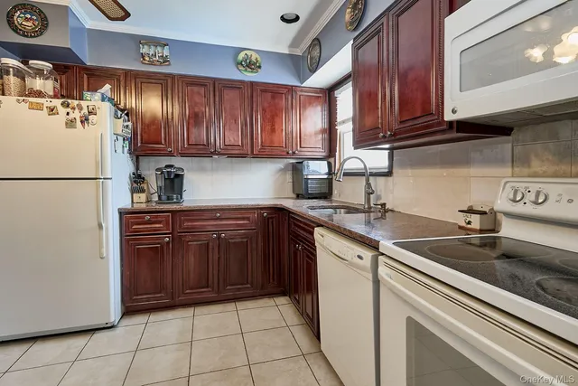 a kitchen with a refrigerator sink and cabinets