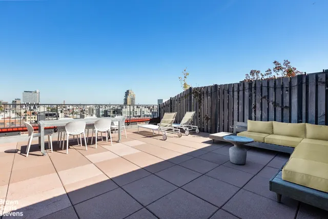 a living room with furniture a flat screen tv and kitchen view