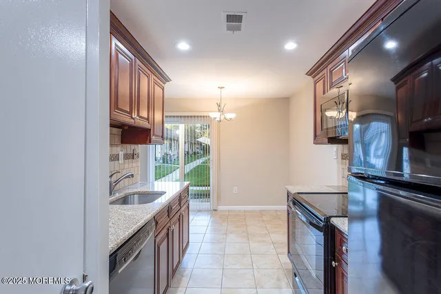a kitchen with kitchen island granite countertop a sink appliances and cabinets