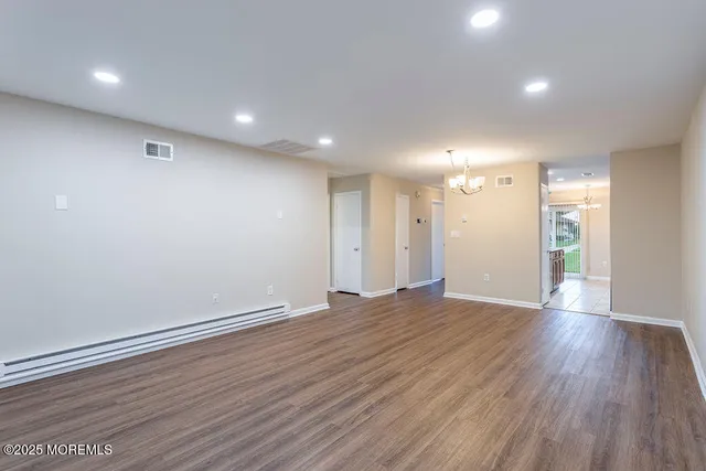 a view of an empty room with wooden floor