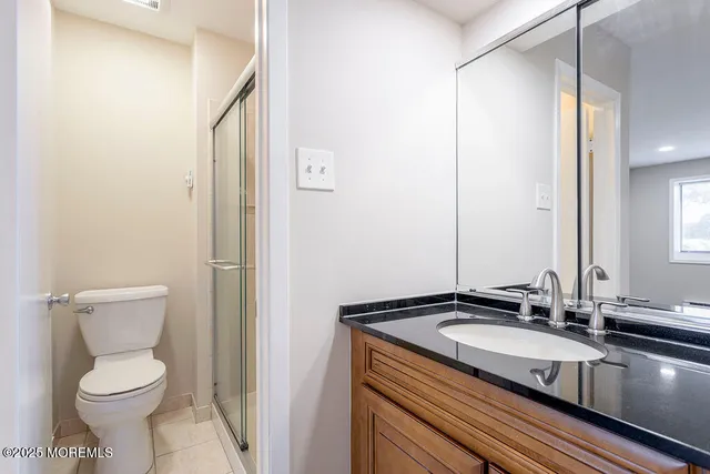 a bathroom with a granite countertop sink toilet and shower