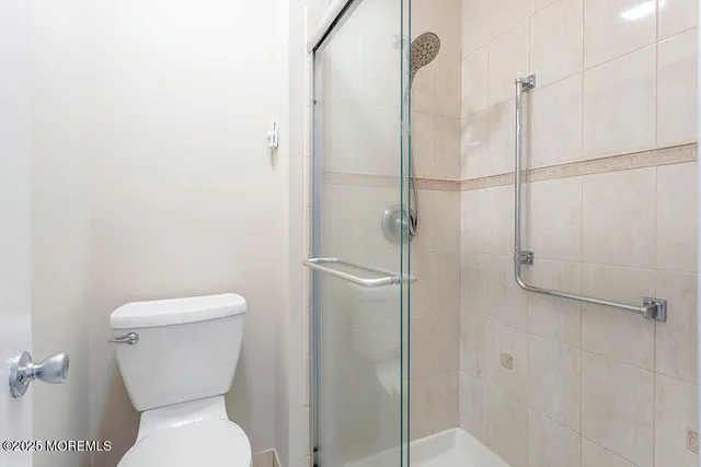 a bathroom with a toilet and a shower