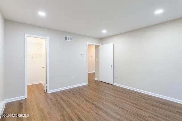 an empty room with wooden floor and closet