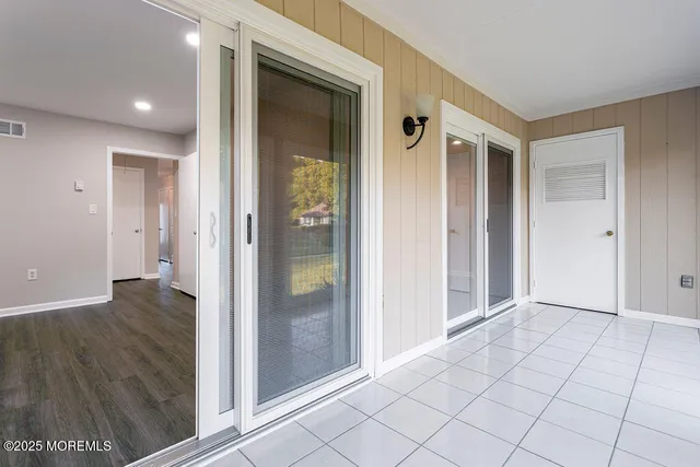 a view of a hallway with wooden floor and cabinet