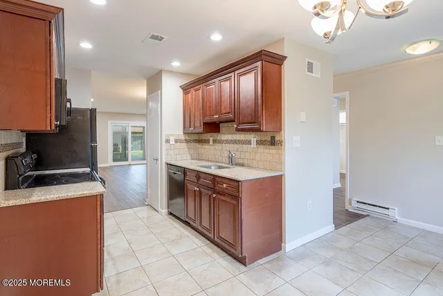 a kitchen with stainless steel appliances granite countertop a stove a sink and a refrigerator