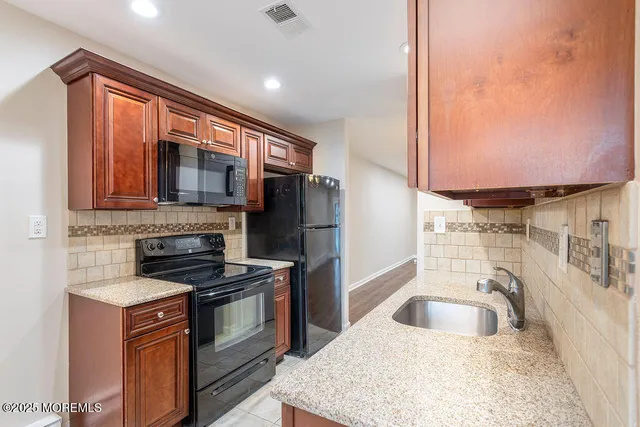 a kitchen with stainless steel appliances granite countertop a sink stove and refrigerator