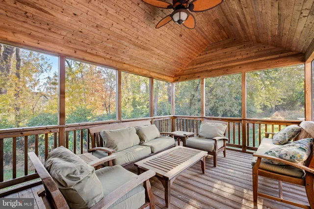 a view of a patio with table and chairs under an umbrella with wooden floor