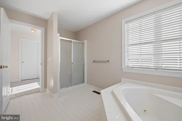 a bathroom with a sink a toilet a large mirror and a window