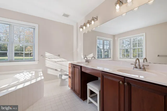 a spacious bedroom with a bed a chandelier and a window