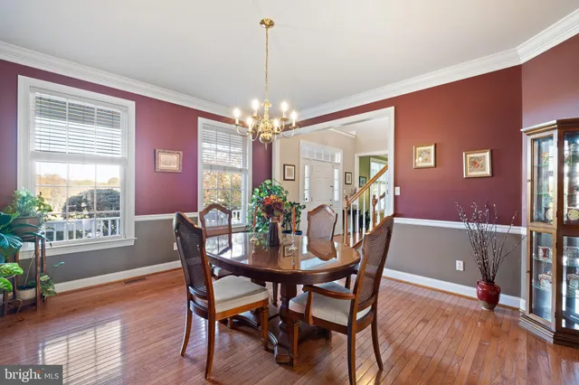 a view of a dining room with furniture a chandelier and wooden floor