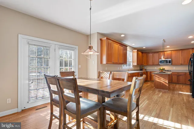 a large kitchen with wooden floors and stainless steel appliances