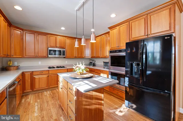 a kitchen with a sink a counter top space appliances and cabinets