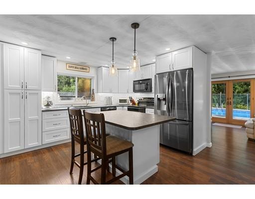5 Samuel Road Chelmsford, MA 01824 - Photo 1 of 17 a kitchen with stainless steel appliances a dining table chairs refrigerator and microwave