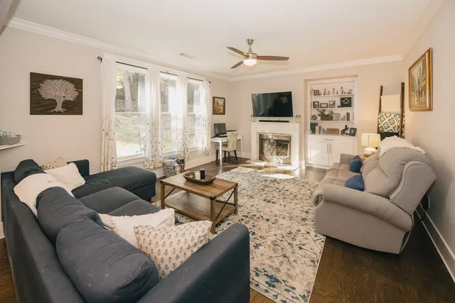 a kitchen with stainless steel appliances kitchen island granite countertop a refrigerator a stove a sink a dining table and chairs with wooden floor