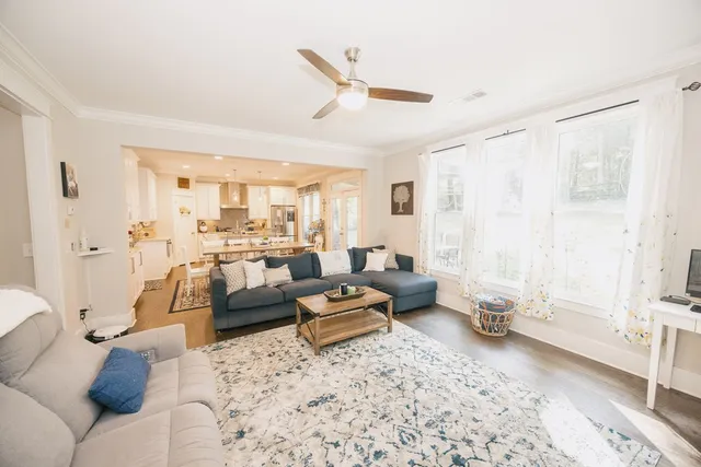 a kitchen with stainless steel appliances granite countertop a refrigerator a stove a sink a dining table and chairs with wooden floor