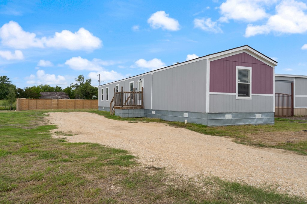 a view of backyard of house with green space