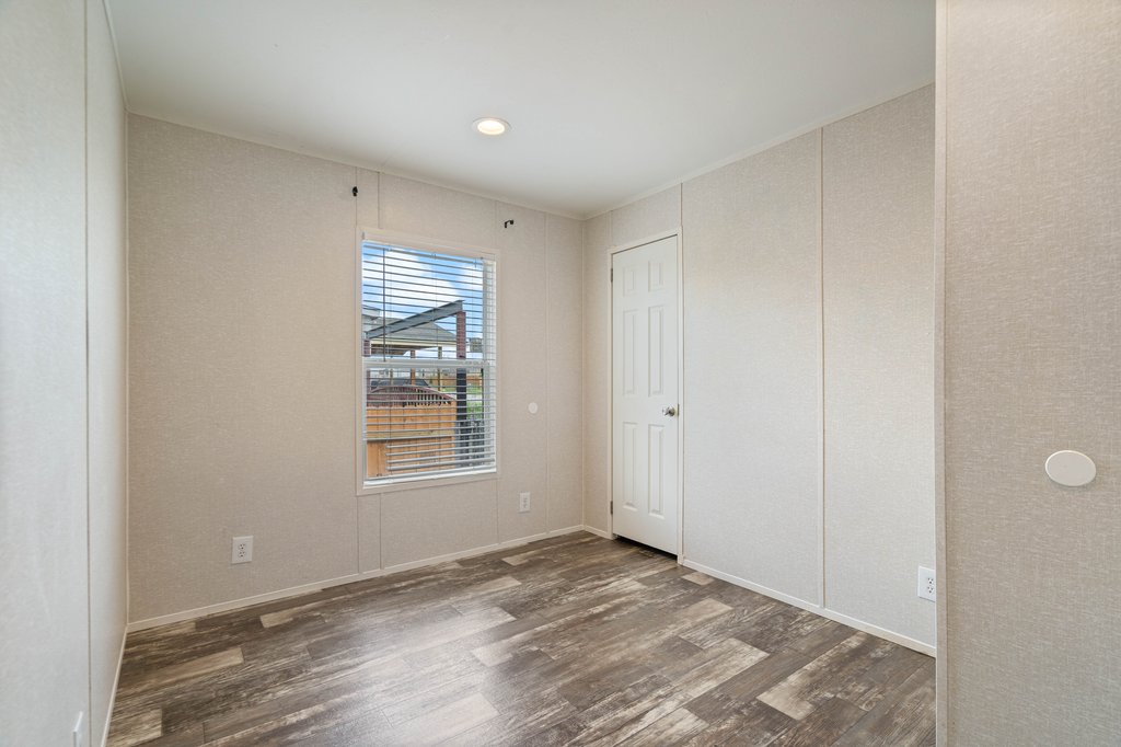 750 Conchas Street Kyle, TX 78640 - Photo 9 of 12 a view of an empty room with wooden floor and a window