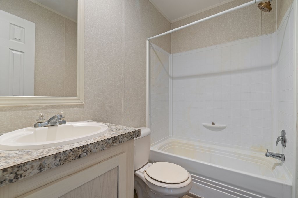 750 Conchas Street Kyle, TX 78640 - Photo 10 of 12 a bathroom with a granite countertop sink a toilet and shower