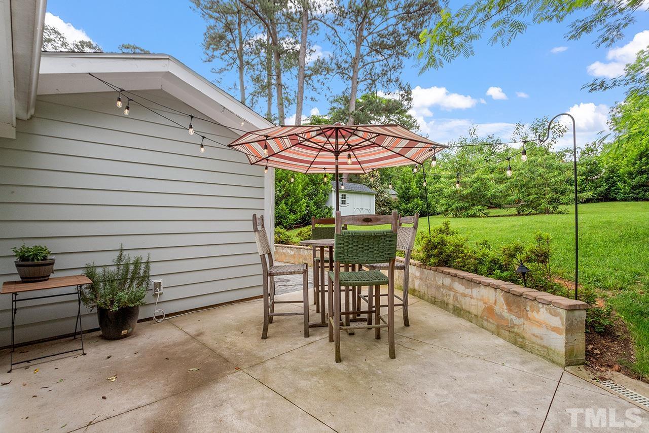 2214 Glascock Street Raleigh, NC 27610 - Photo 34 of 36 a view of a patio with a table and chairs under an umbrella