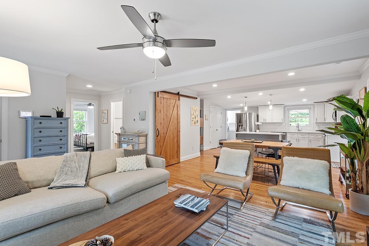 2214 Glascock Street Raleigh, NC 27610 - Photo 9 of 36 a view of living room kitchen with a dining table wooden floor and a ceiling fan