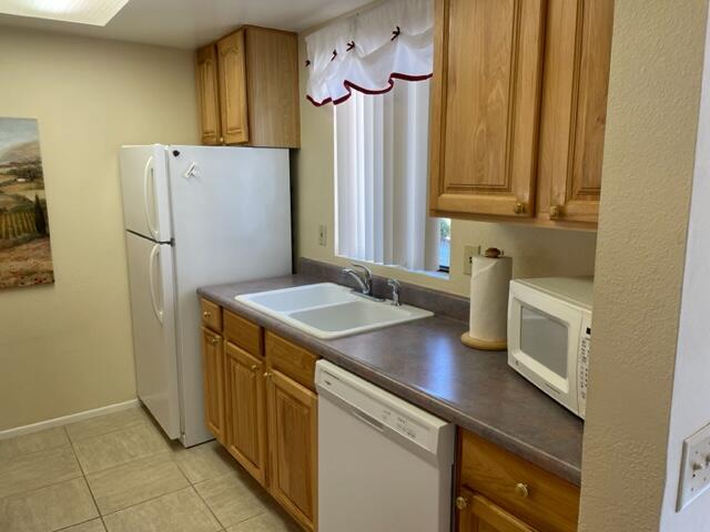 77413 Sawgrass Circle Palm Desert, CA 92211 - Photo 9 of 12 a kitchen with a refrigerator sink and cabinets