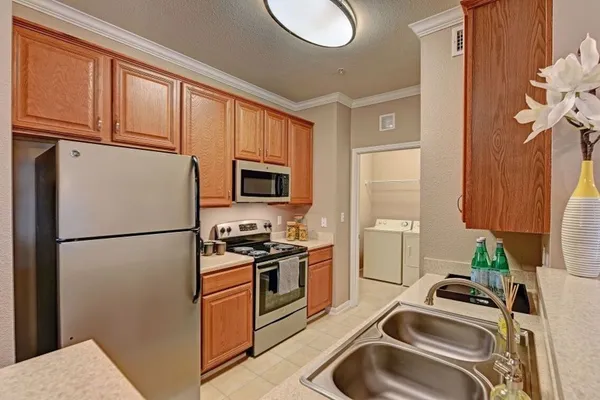 a kitchen with a sink a refrigerator and cabinets