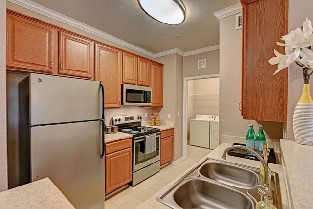 a kitchen with a sink a refrigerator and cabinets