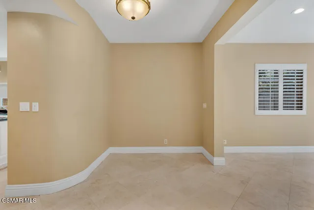 a view of an empty room with a fireplace and a window