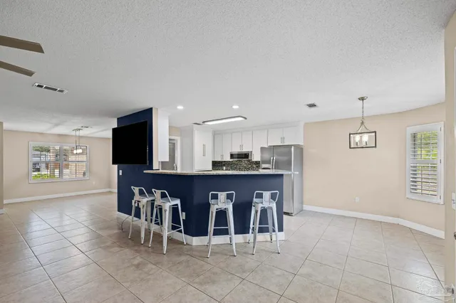 a kitchen with granite countertop white cabinets and stainless steel appliances